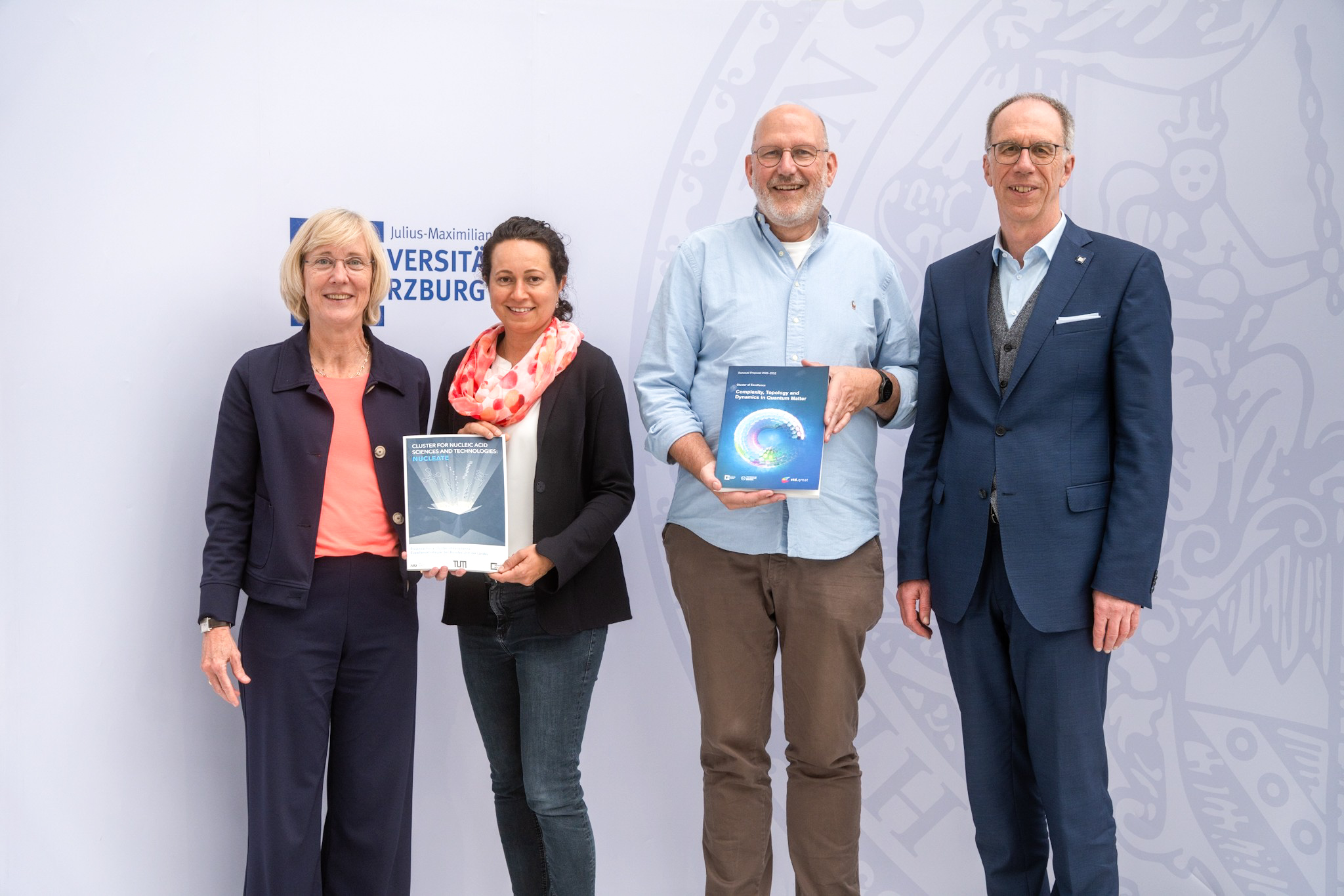 Freude über den Doppelerfolg: Zwei Würzburger Forschungsvorhaben haben sich im Exzellenzwettbewerb durchgesetzt und erhalten Mittel aus der begehrten Millionenförderung. Von links: Caroline Kisker (Würzburger Koordinatorin von NUCLEATE und Vizepräsidentin), Cynthia Sharma (Würzburger Speakerin von NUCLEATE), Ralph Claessen (Würzburger Speaker von ctd.qmat) und Universitätspräsident Paul Pauli (Bild: Jonas Blank / JMU)