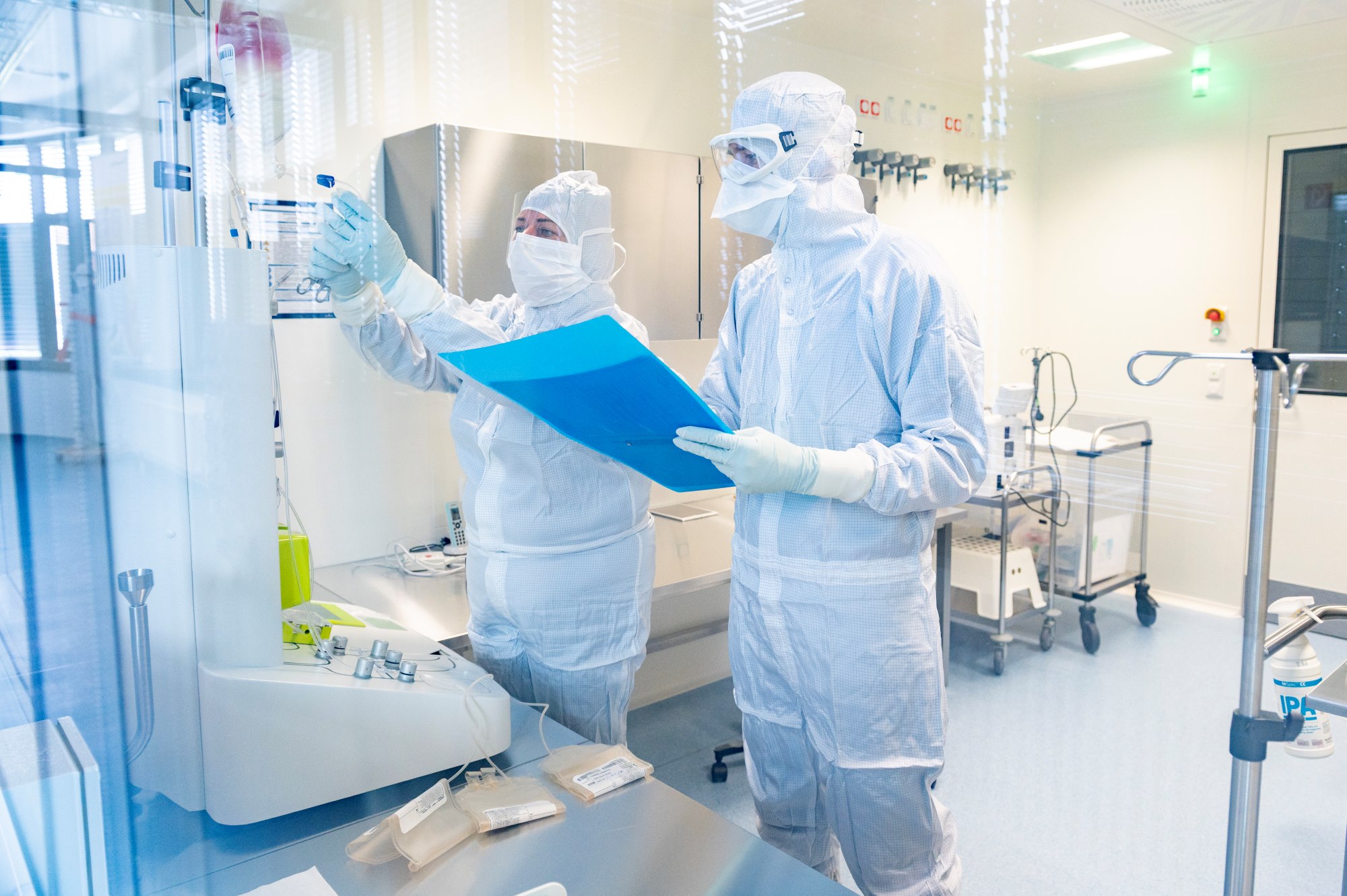 Zwei Personen mit Reinraumoverall, Maske, Handschuhen etc. im Reinraum 