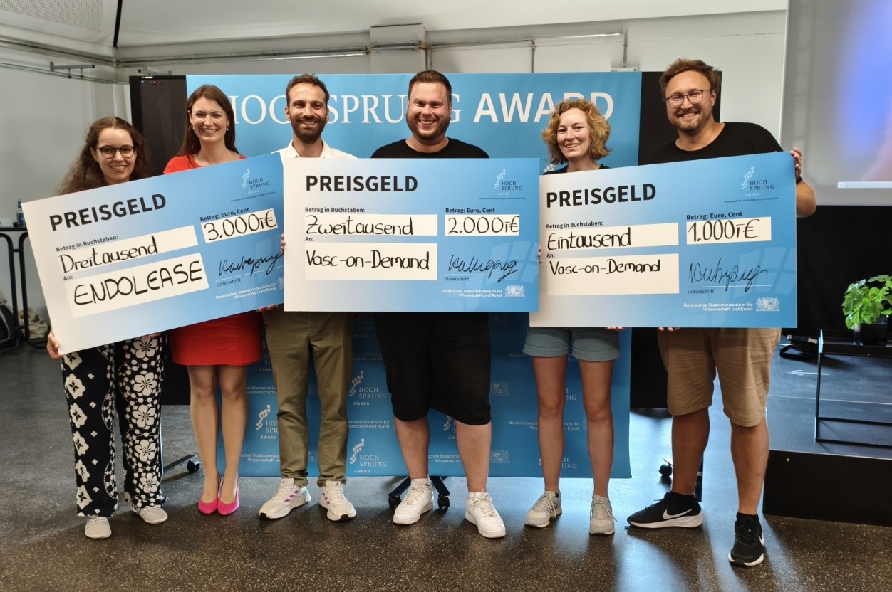 Beide Gewinnerteams mit insgesamt sechs Personen halten 3 überdimensional große Schecks in die Höhe. 