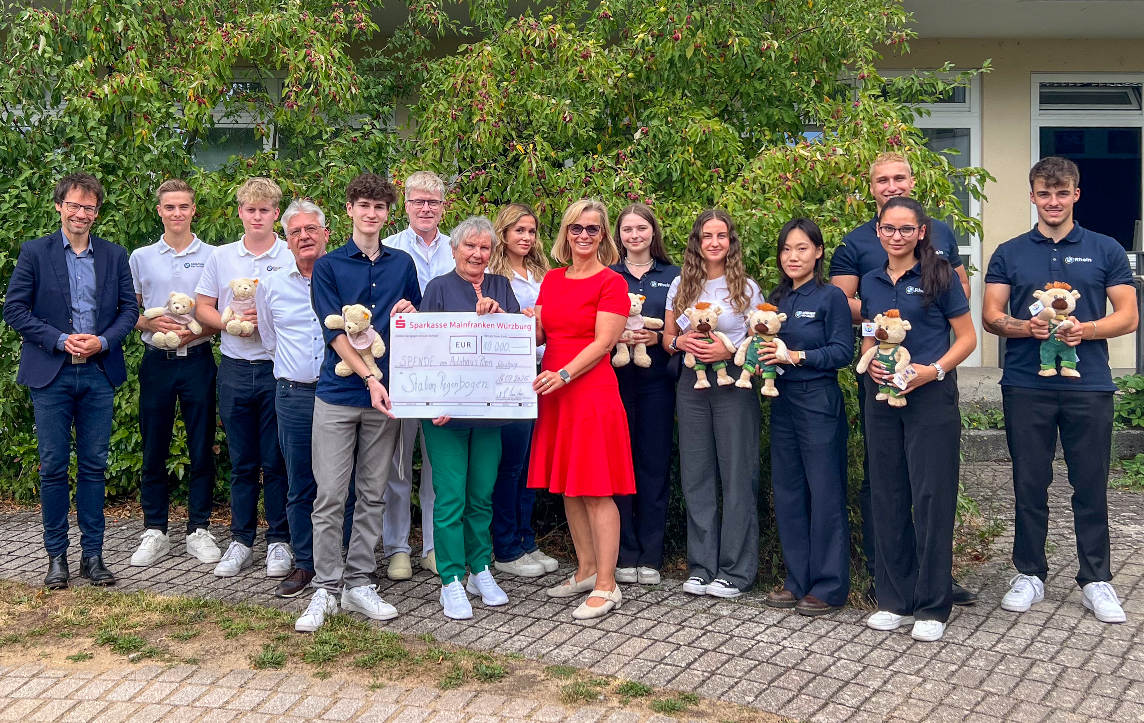 Vertreter der Autohaus-Rhein-Gruppe, der Elterninitiative Regenbogen und der Uni-Kinderklinik bei der Scheckübergabe