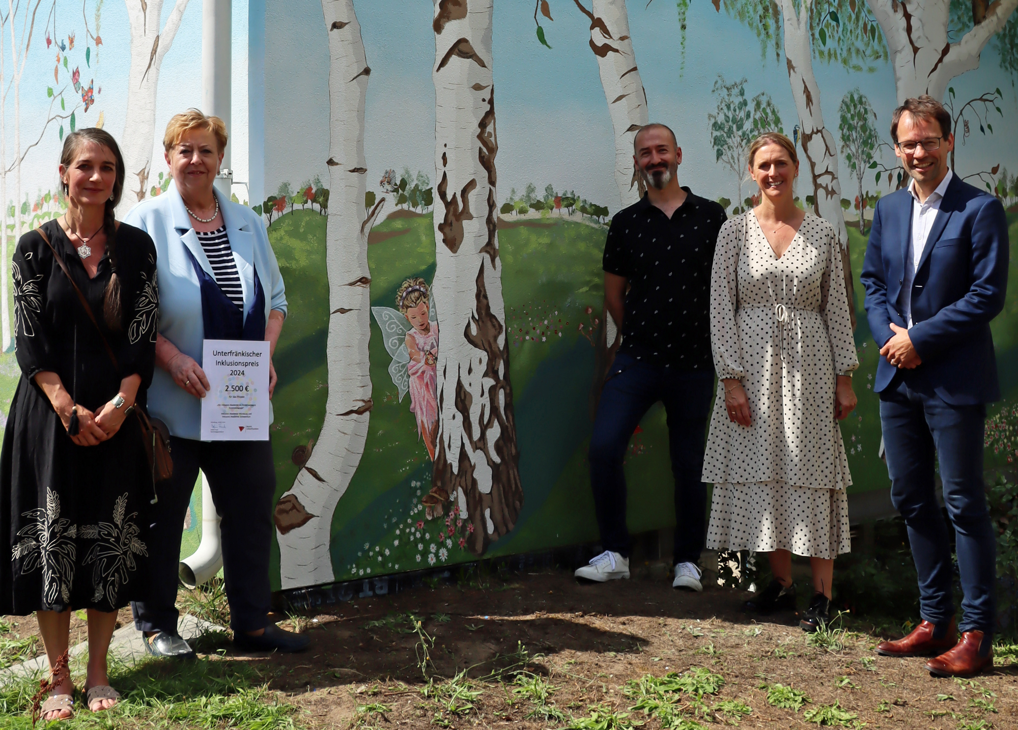 Gruppenbild vor Wandgemälde