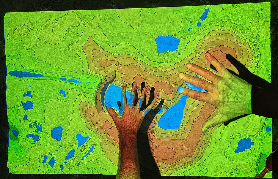 Mit einer Sandbox werden Prozesse simuliert, welche die Oberfläche der Erde verändern. (Bild: Thomas Amend / Universität Würzburg)