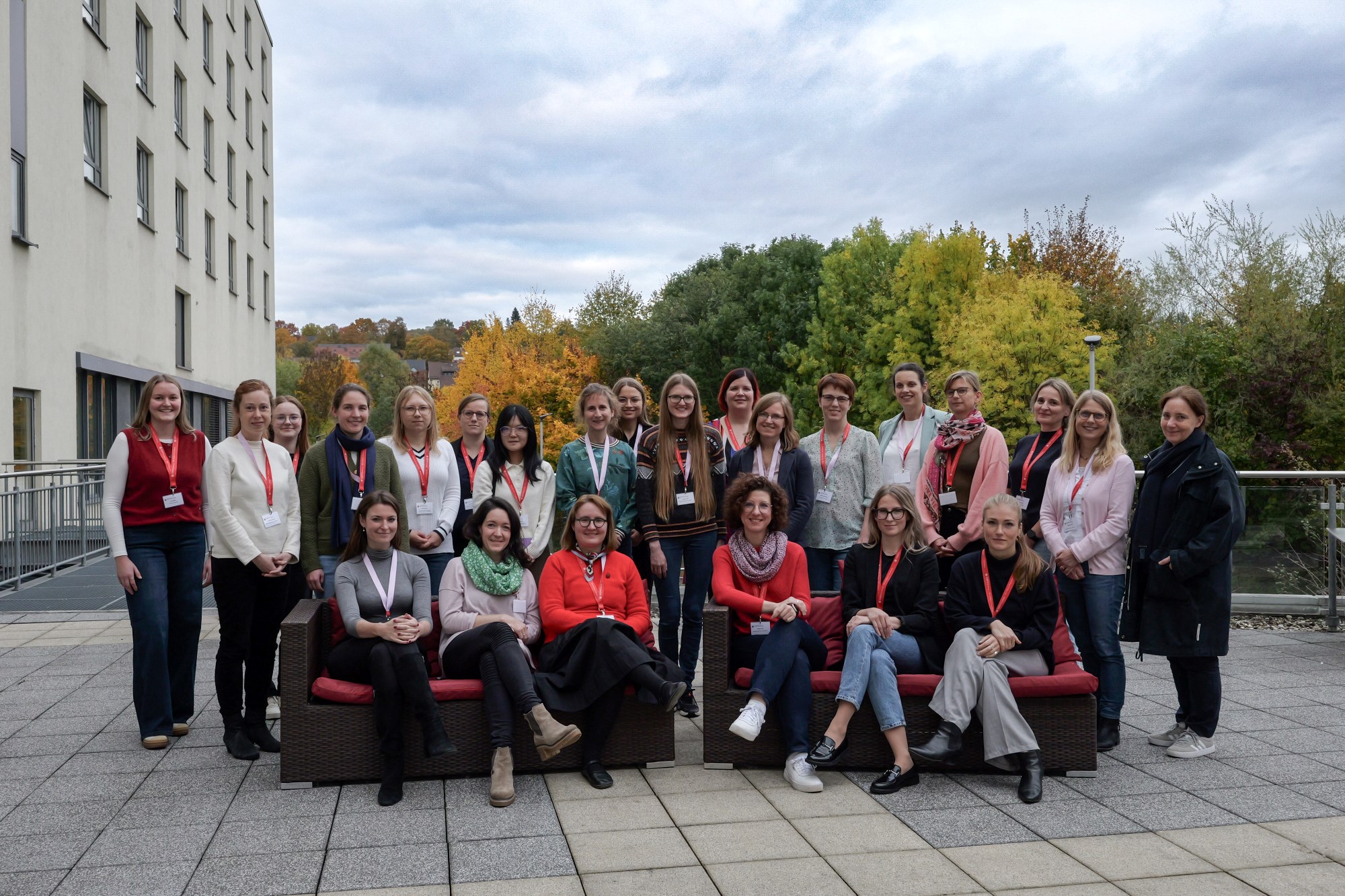 Die Teilnehmerinnen posieren draußen auf einer Hotelterrasse fürs Bild - vorne sitzen sechs Frauen auf zwei Sofas, dahinter gruppieren sich die anderen Frauen. 