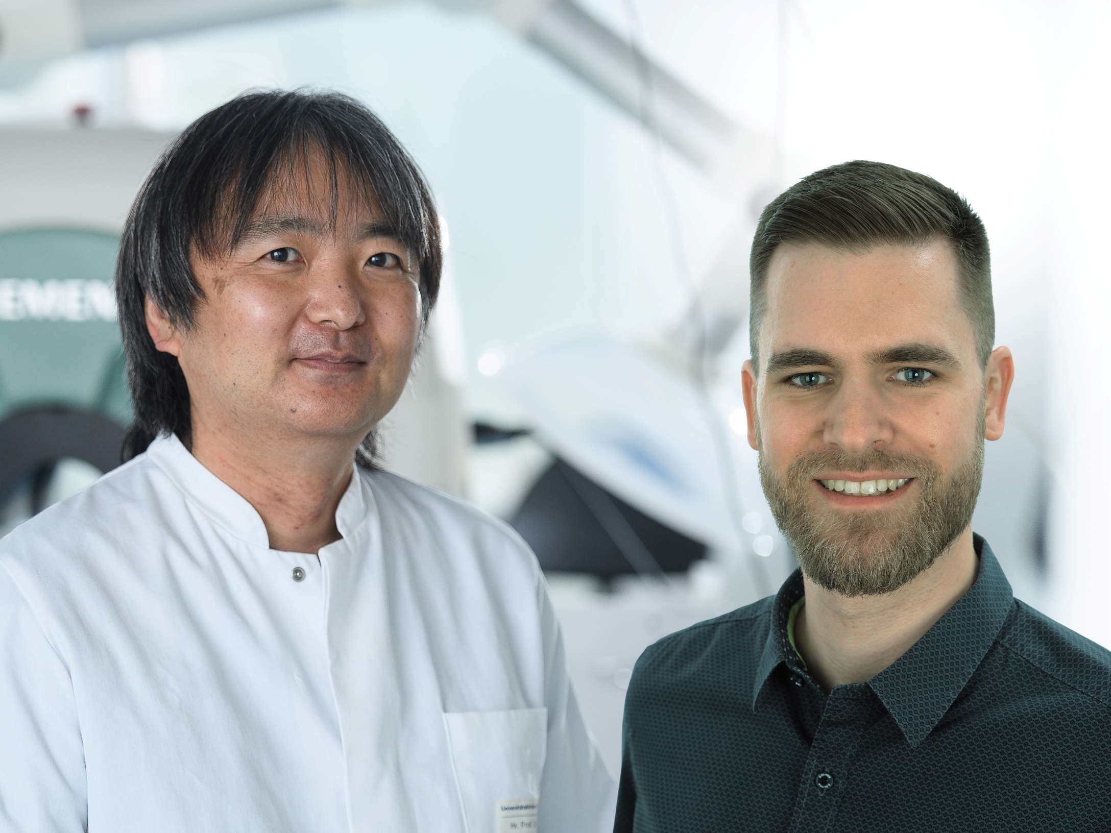 Das bild ist eine Collage und zeigt Takahiro Higuchi im Labor, daneben wurde ein freigestelltes Porträt von Benjamin Heil gesetzt, das sich in die Umgebung einfügt. 