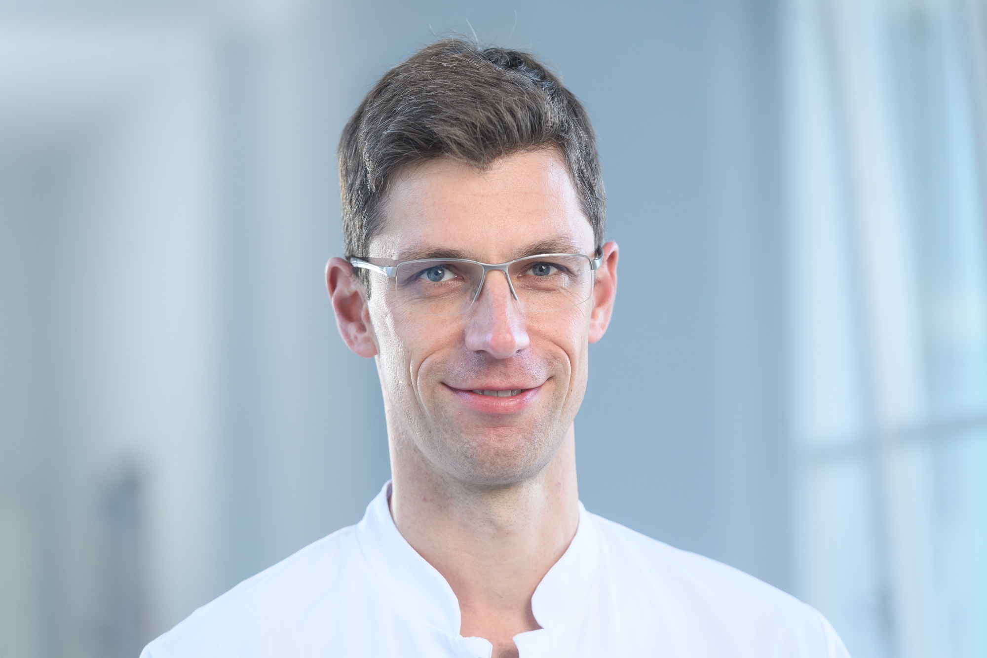 Porträtbild von Patrick Meybohm in weißem Kittel