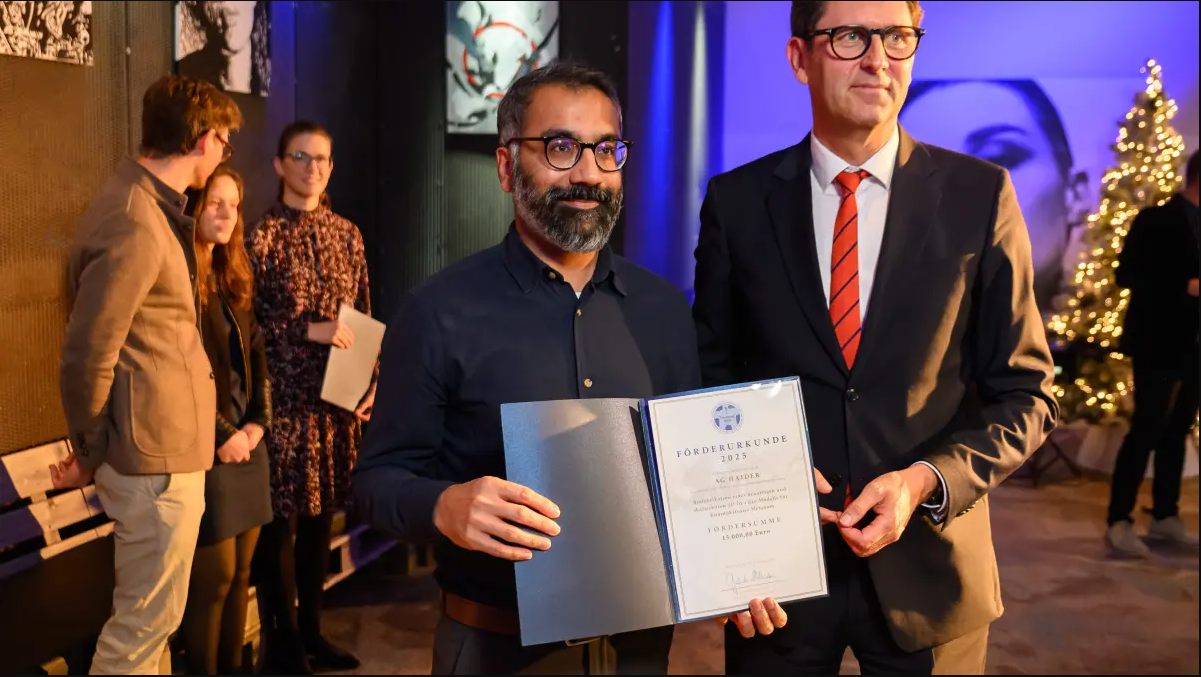 Malik Salman Haider mit Urkunde und daneben Tim von Oertzen. 