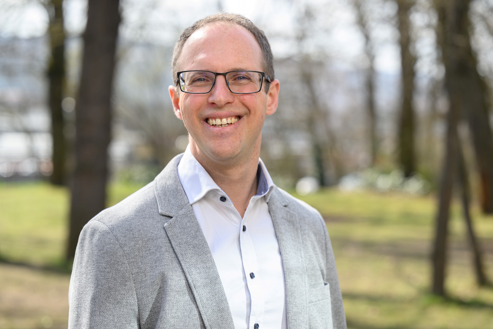 Alexander Soutschek steht im Garten des Zentrums für Psychische Gesundheit 