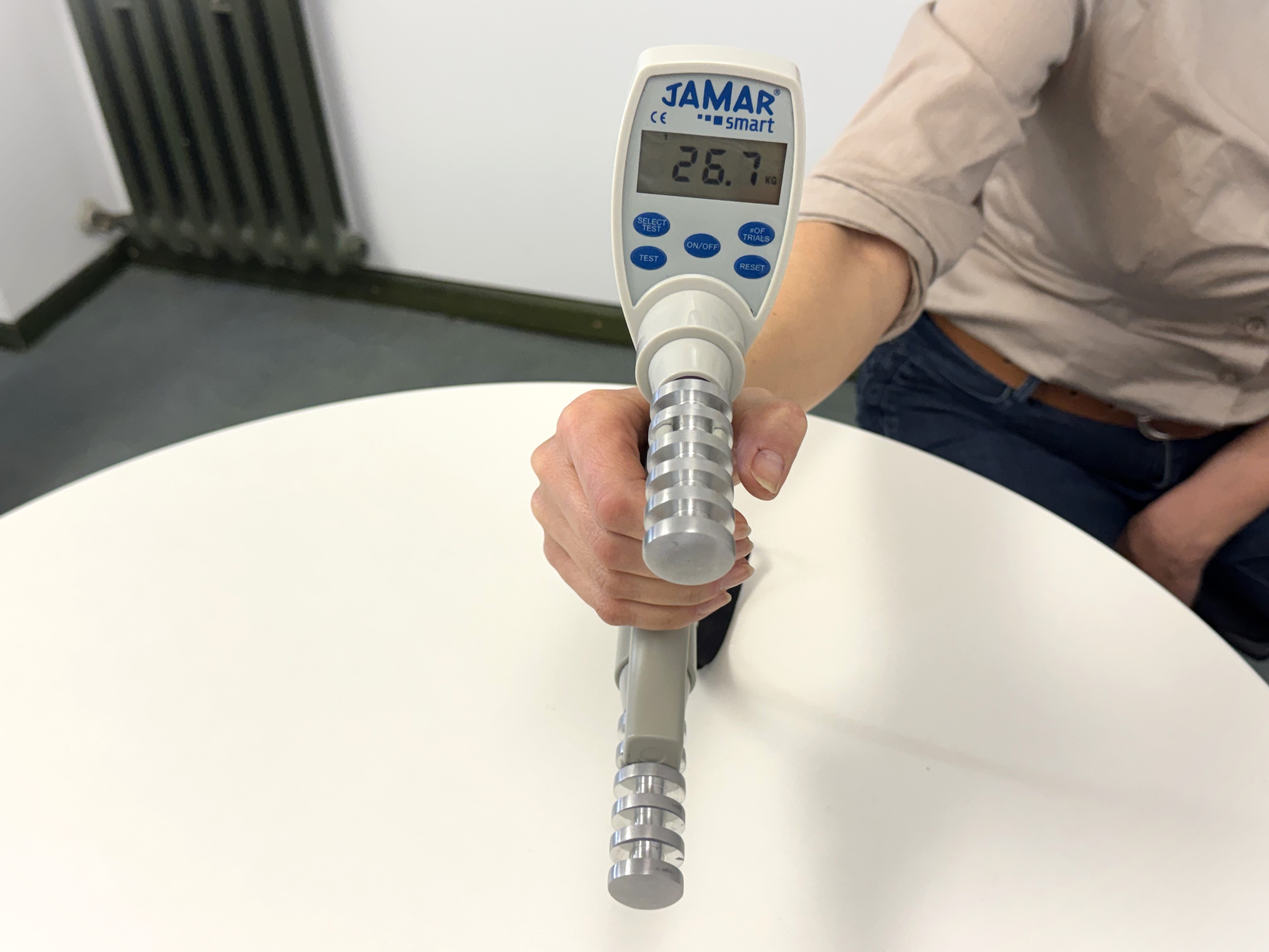 Frau drückt Manometer, das 26,7 kg zeigt. 