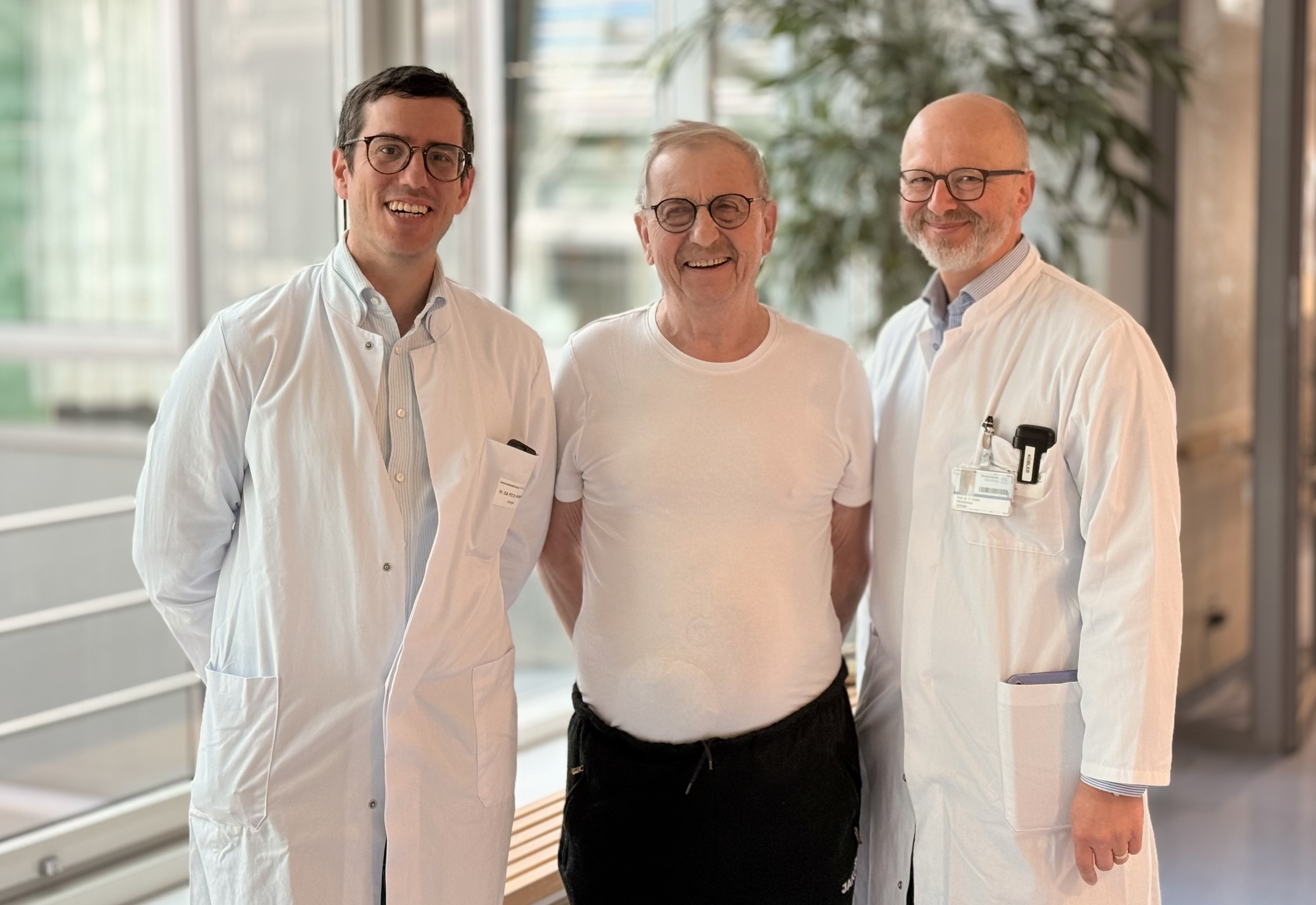 Patient steht zwischen seinen Ärzten in der Magistrale des Zentrums für Operative Medizin. 