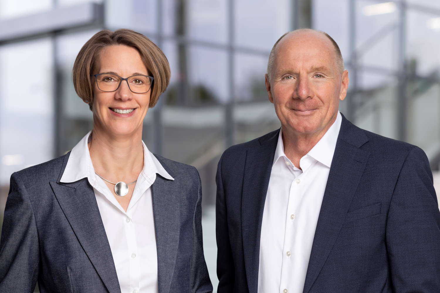 Porträt von Valerie Orth und Bernhard Nieswandt - beide tragen ein helles Hemd bzw. Bluse und ein dunkles Jacket bzw. Blazer. 