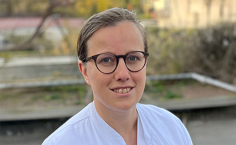 Porträtbild von Sabine Drossard - sie trägt Haare zurück, dunkle Brille und weißen Kittel 