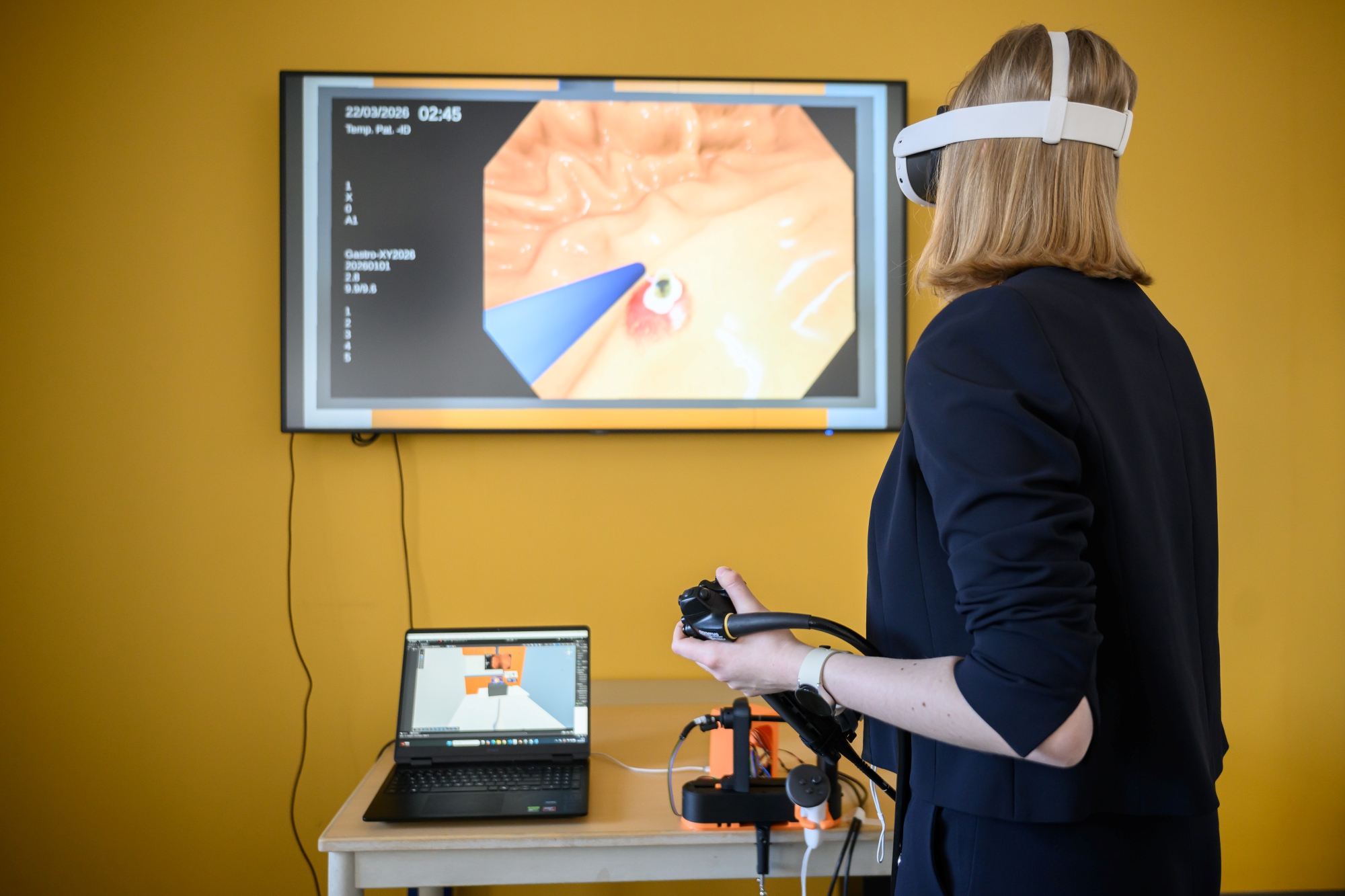Game-Developerin mit VR-Brile und Endoskop vor Monitor.