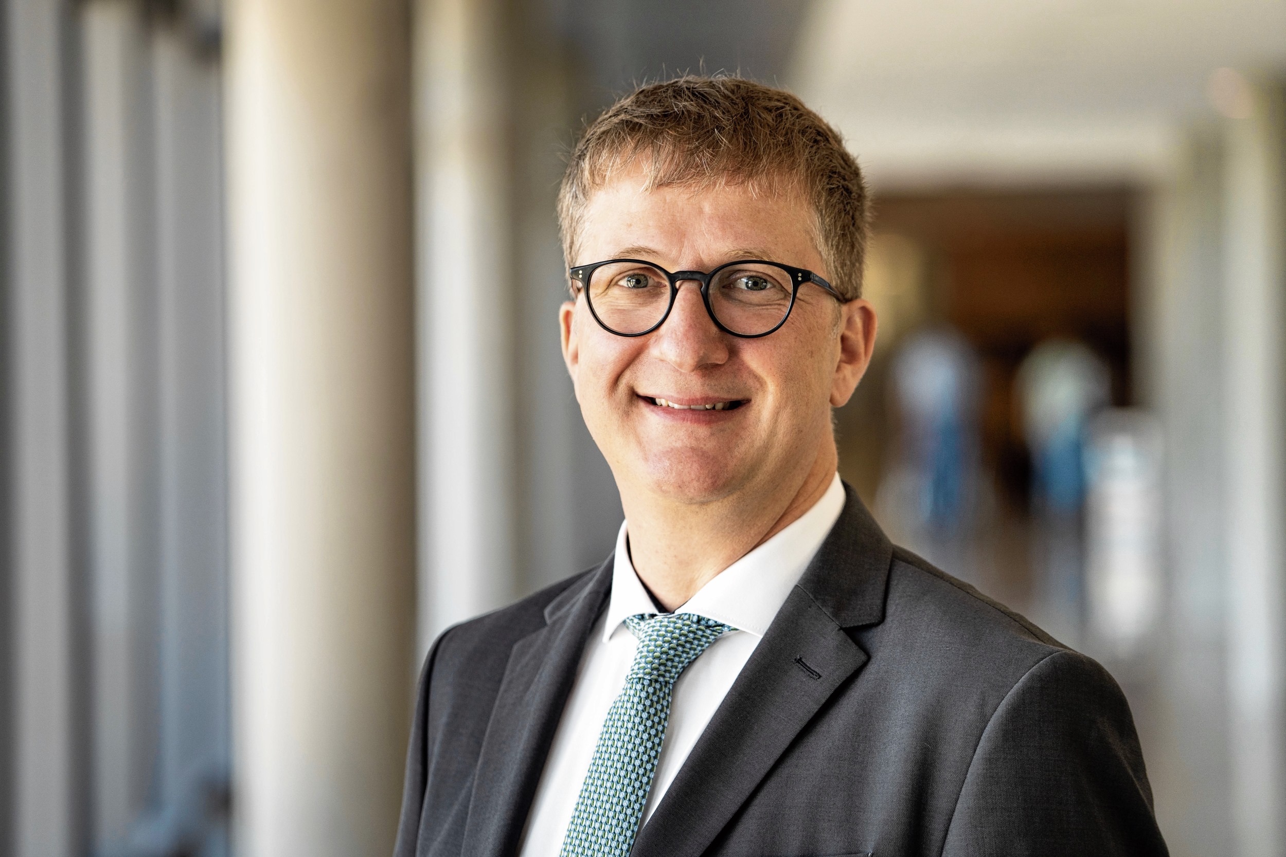 Porträt von Sebastian Walther im Anzug mit Krawatte 