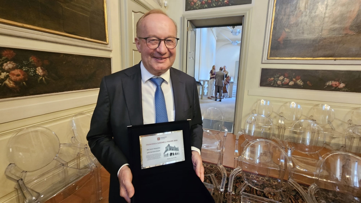 Hermann Einsele hält Urkunde in den Händen und strahlt in die Kamera 