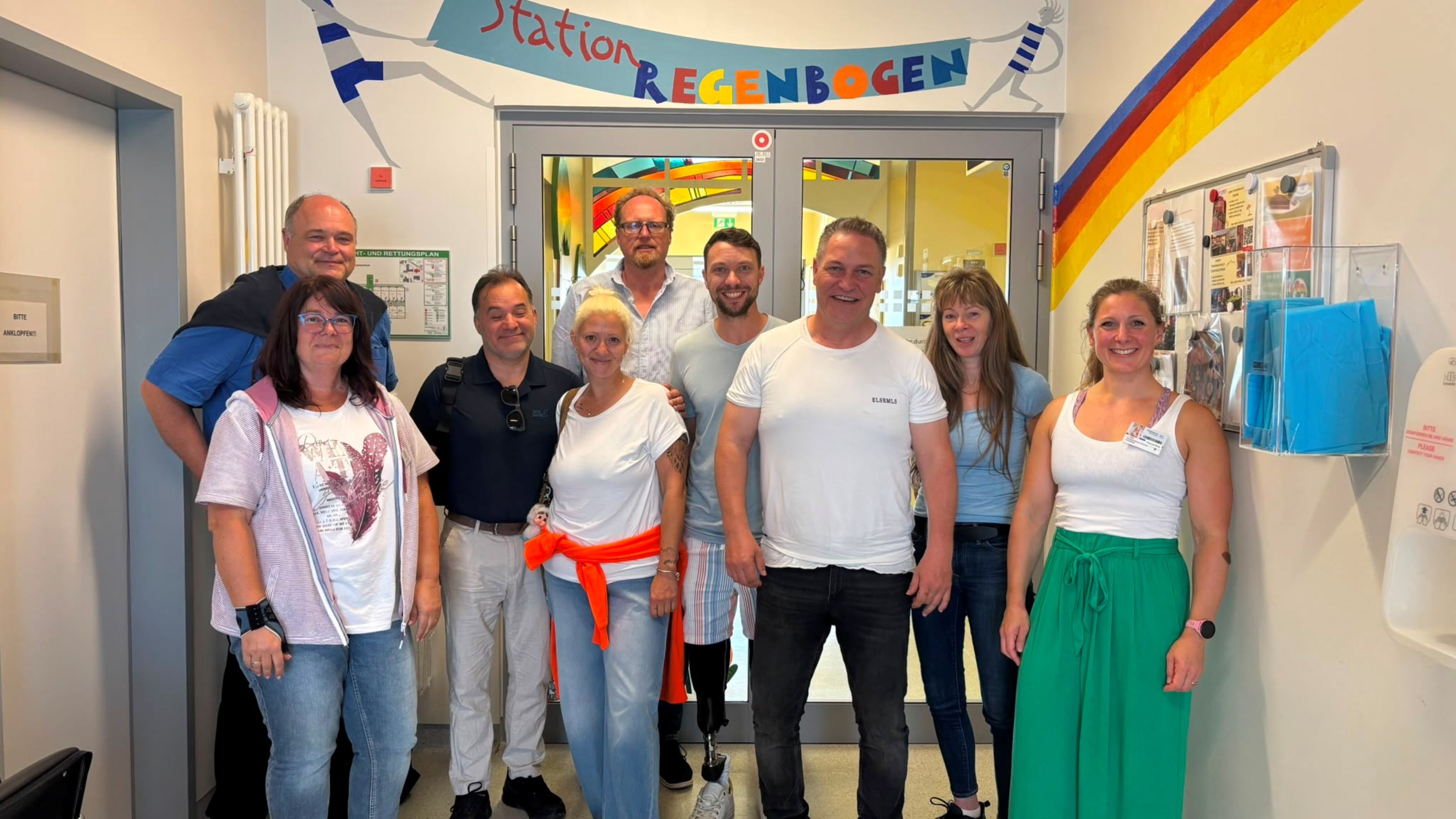 Vertreterinnen und Vertreter der Elterninitiative Regenbogen, vom Fachbereich Sport der Stadt Würzburg, Annettes Kinderturnen und Sporttherapeutin der Stationen in der Kinderklinik im Flur der Station Regenbogen..