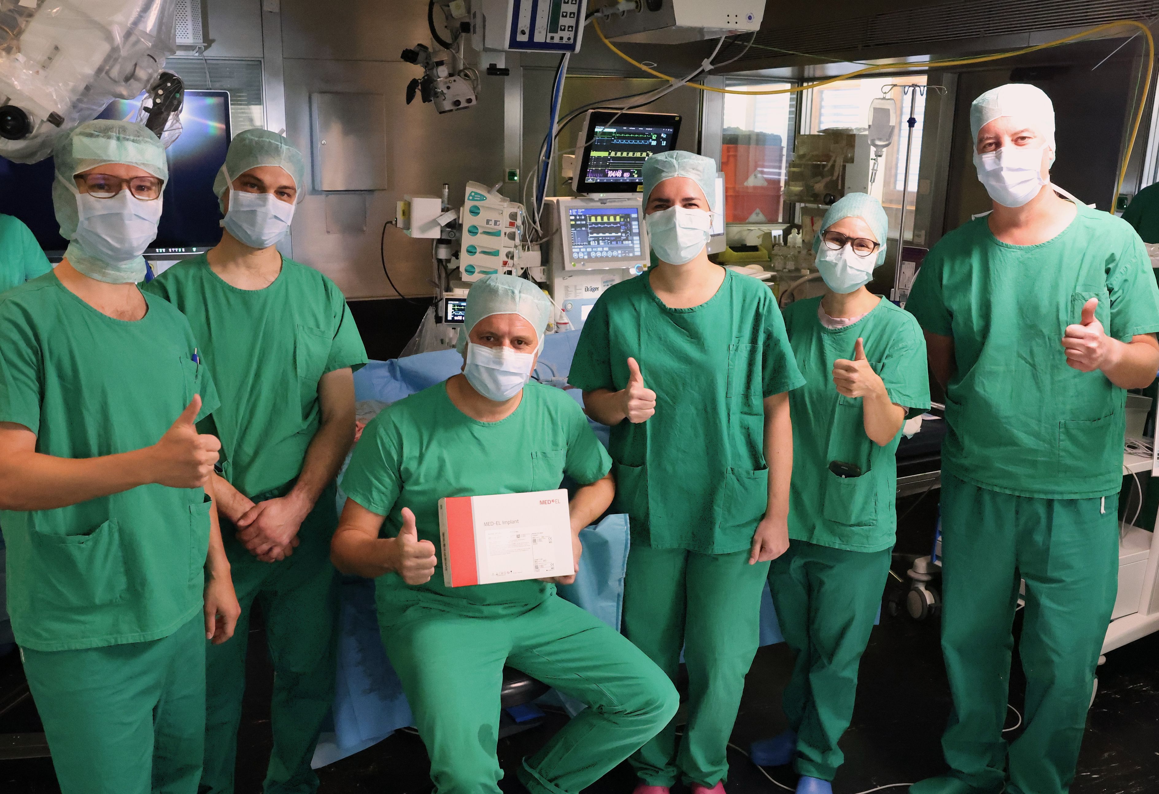 Freuen sich über die erfolgreiche Weltpremiere an der HNO-Klinik: Das Team um Prof. Dr. Kristen Rak (sitzend) und PD Dr. Anja Kurz (2.v.r.). Foto: UKW / Kim Sammet