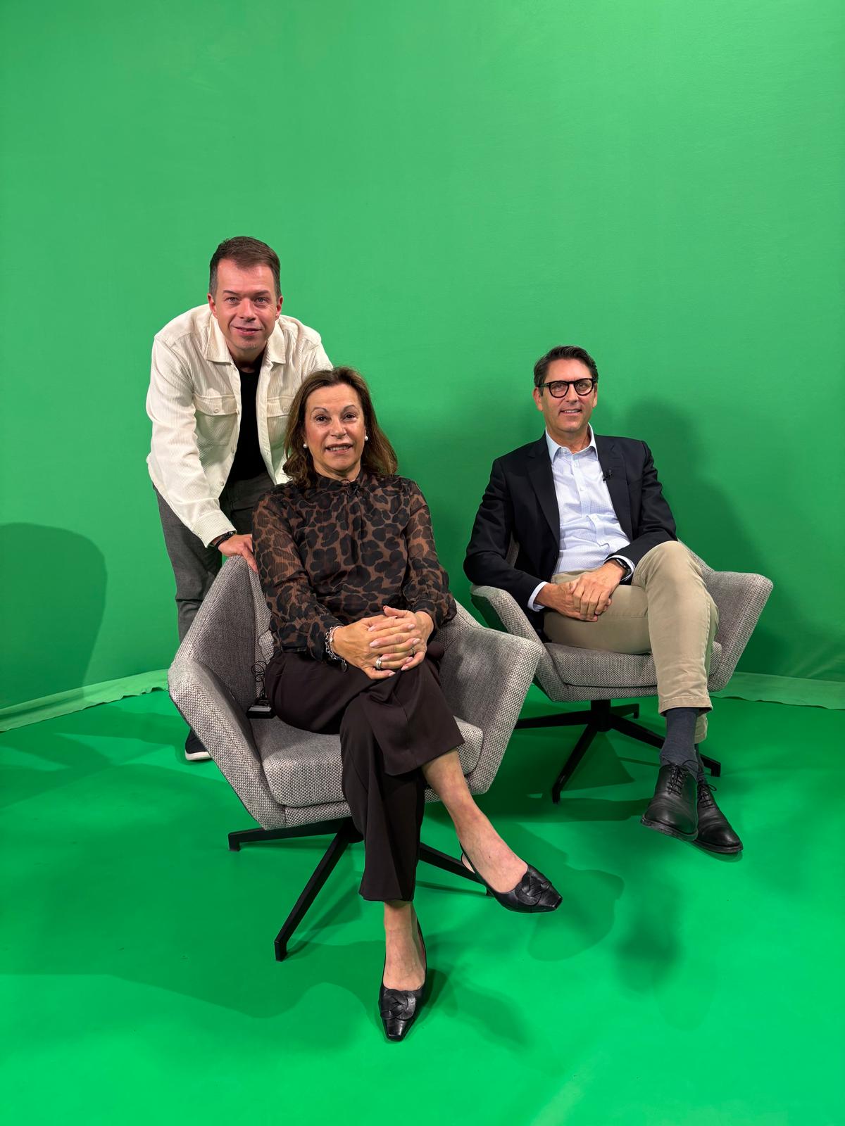 Moderator mit Frau Nelkenstock und Prof. Tim J. von Oertzen im Studio von TV Mainfranken. Hintergrund und Fußboden sind grün.