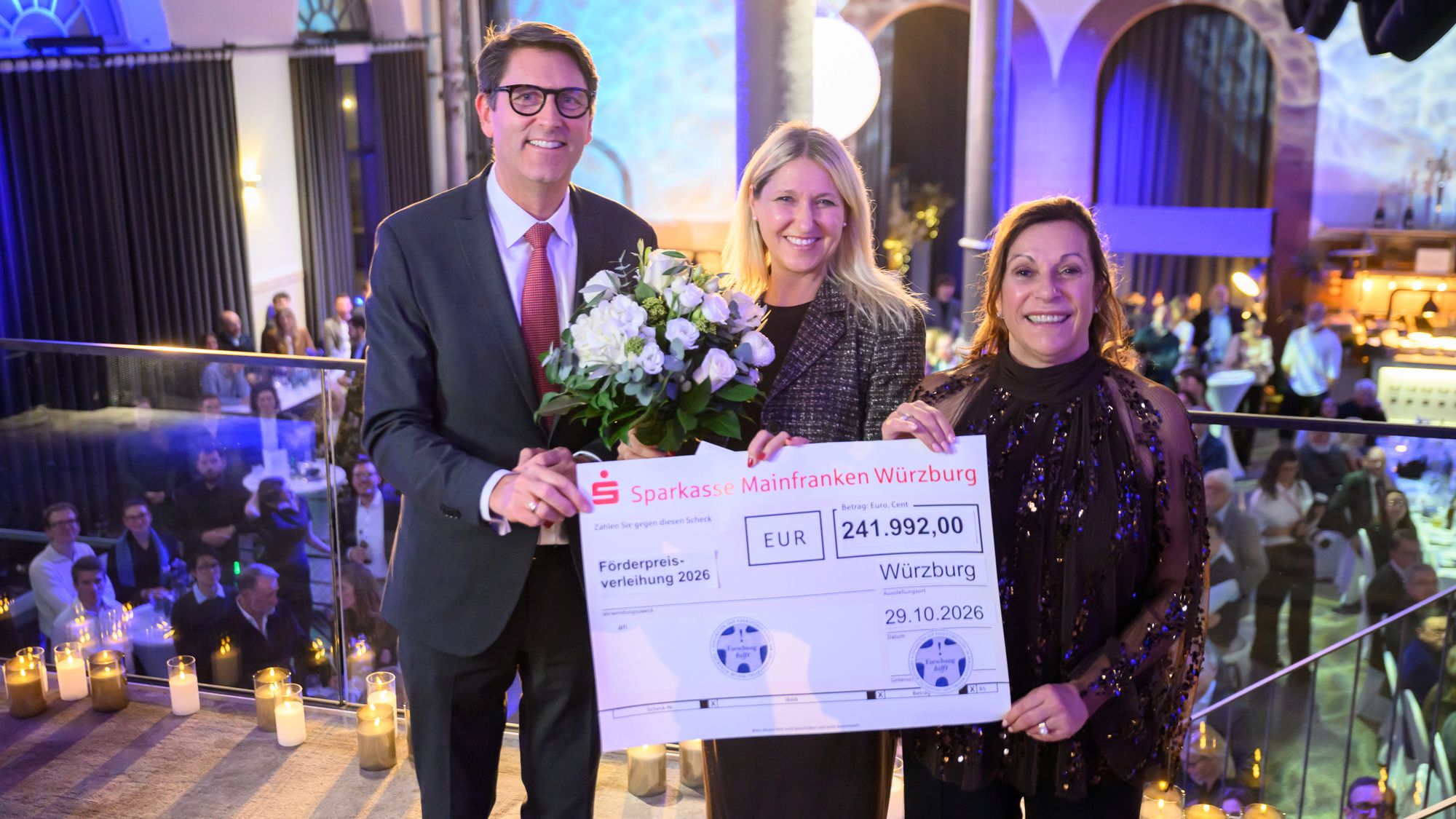Prof. Dr. Tim J. von Oertzen, Ärztlicher Direktor des Uniklinikums Würzburg, Staatssekretärin Dr. Silke Launert und Stiftungsratsvorsitzende Gabriele Nelkenstock (von links) präsentieren die Gesamtfördersumme, die in diesem Jahr an die Forschungsteams ausgeschüttet wurde. Foto: Daniel Peter / UKW