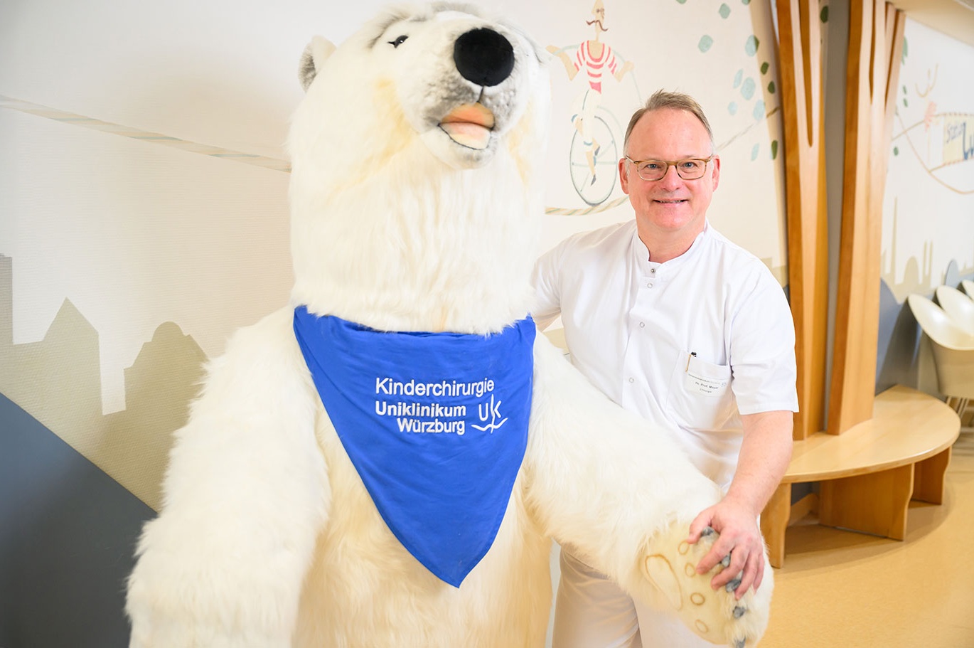 Prof. Dr. Thomas Meyer, Leiter der Sektion für Kinder- und Jugendchirurgie, Kinderurologie und Kindertraumatologie der Chirurgischen Klinik I, steht vor dem Maskottchen der Station, einem großen Eisbären.