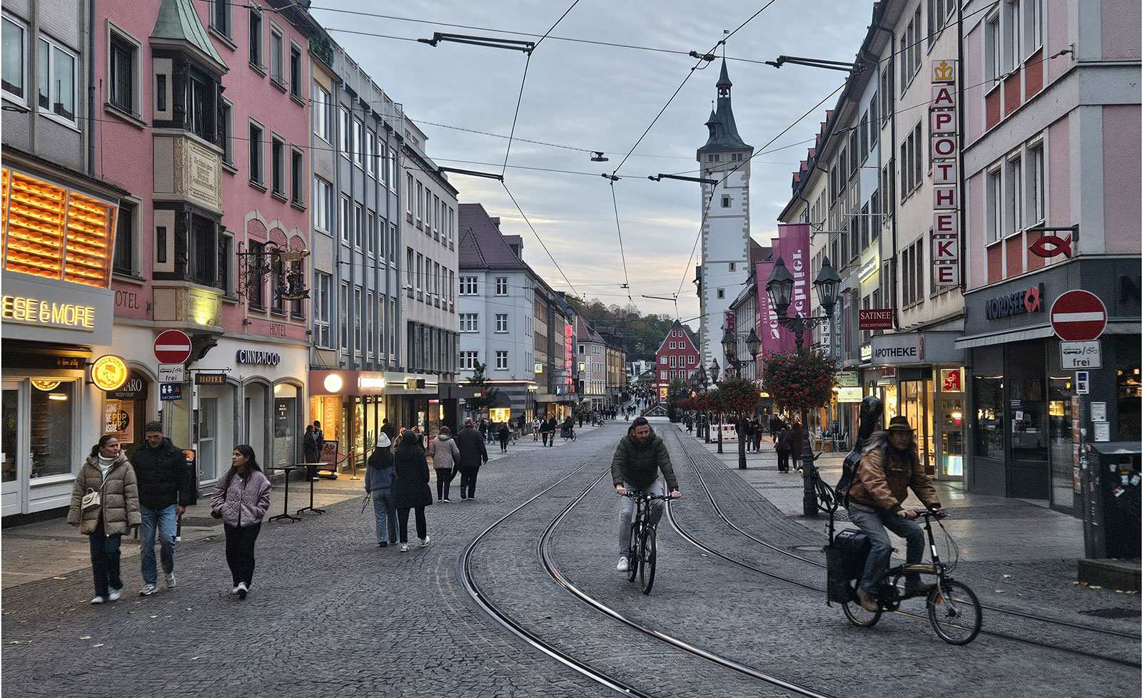 Blick auf die Würzburger Domstrasse mit Geschäften links und rechts und Passanten.