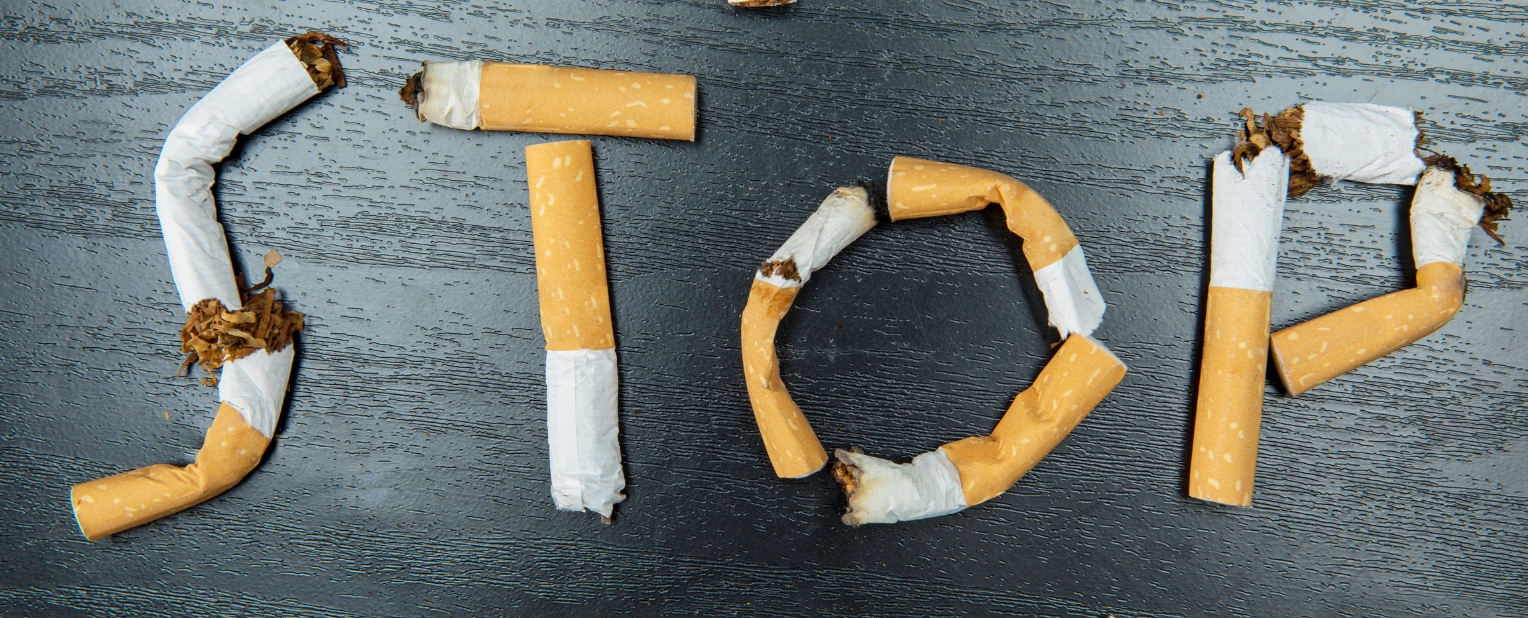 Das Wort "Stop" gelegt aus gerauchten Zigaretten