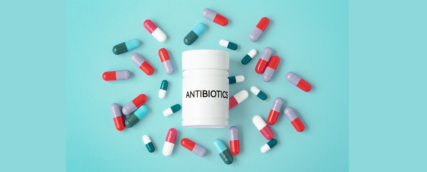 Die Abbildung zeigt eine weiße Medikamentendose und drumherum viele Pillen.