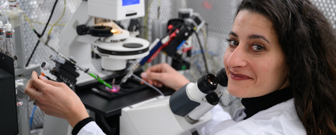 Margarita Habib Forscherin im weißen Kittel im Labor am Mikroskop