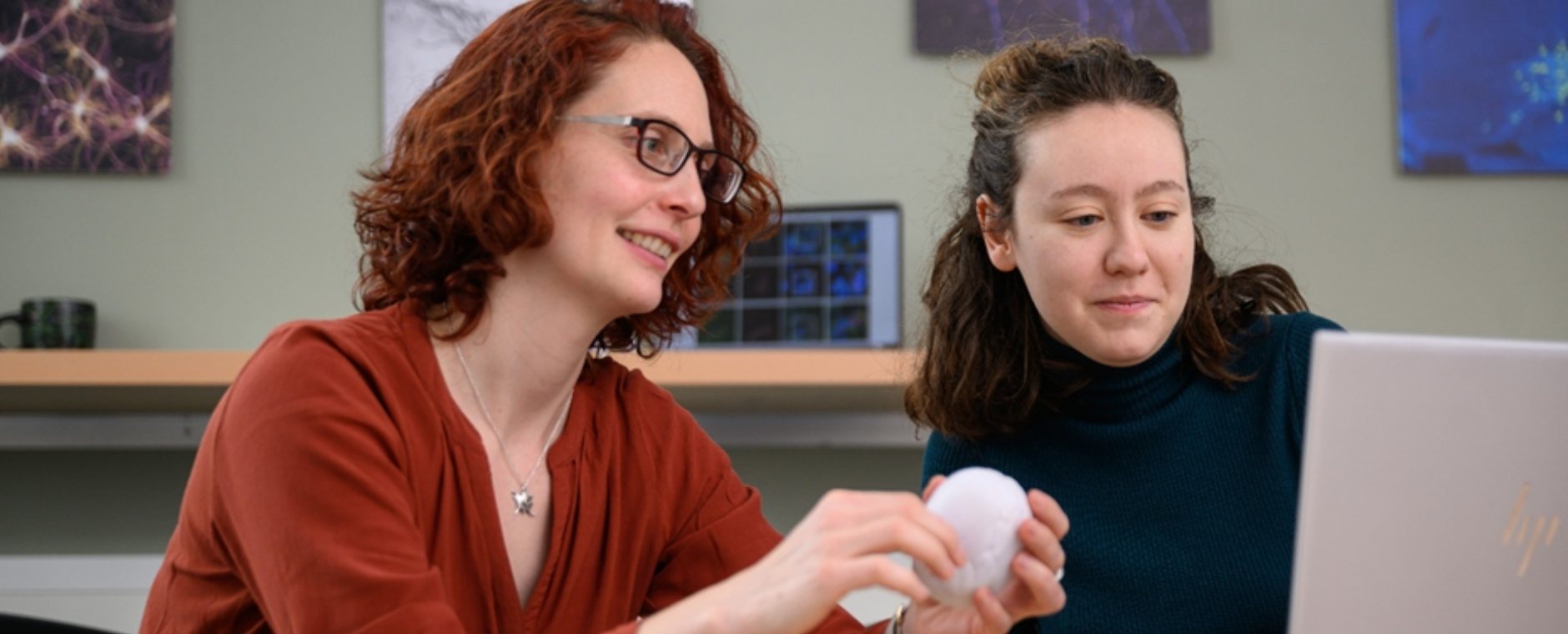 die beiden Forscherinnen in der Küche der Neurobiologie mit Laptop und Gehirnmodell