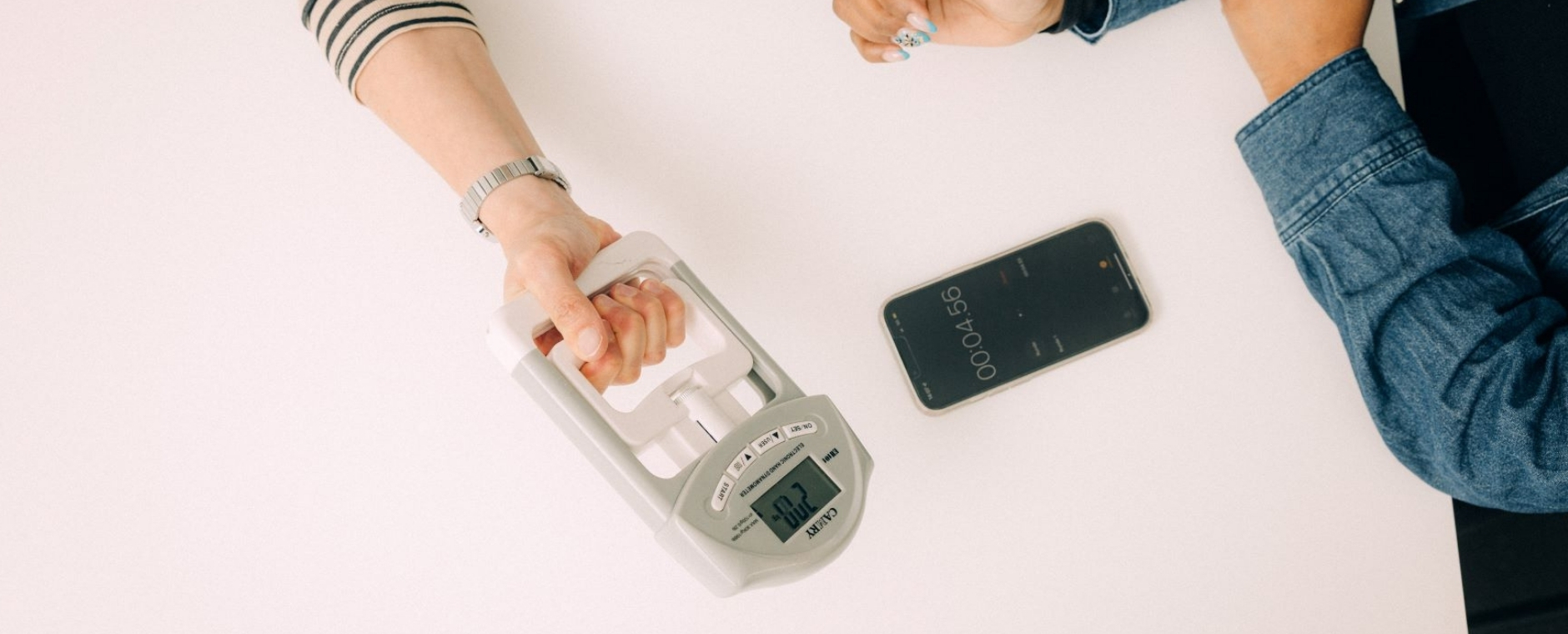 Person hält elektronischen Manometer, andere Person misst die Zeit