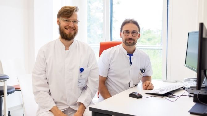 Zwei Mitarbeitende im Bereich Public Health sitzen am Schreibtisch